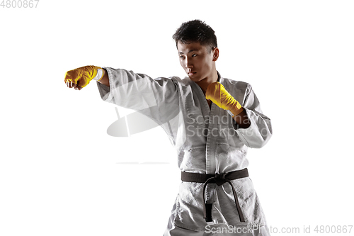 Image of Confident korean man in kimono practicing hand-to-hand combat, martial arts