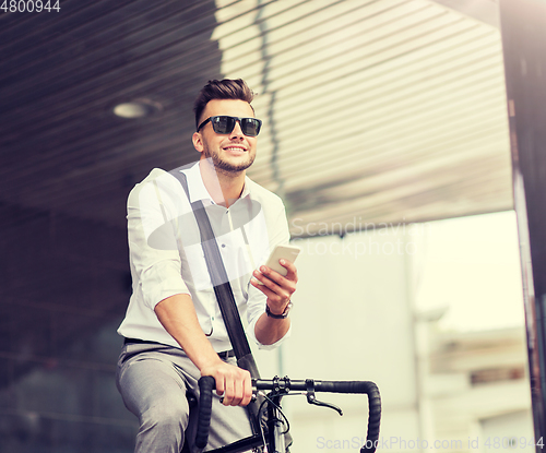 Image of man with bicycle and smartphone on city street