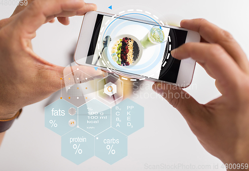 Image of hands with phone and food nutritional value chart