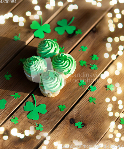 Image of green cupcakes and shamrock on wooden table