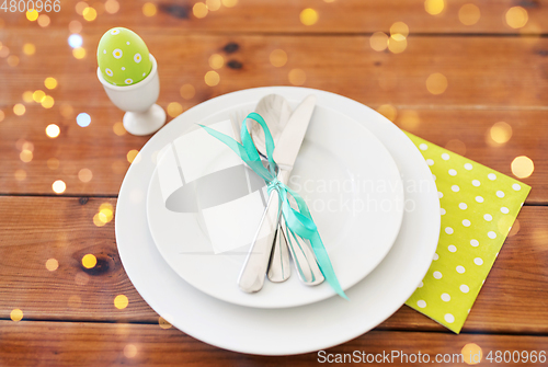 Image of easter egg in cup holder, plates and cutlery