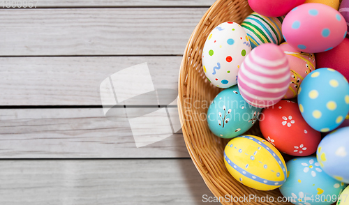 Image of close up of colored easter eggs in wicker basket