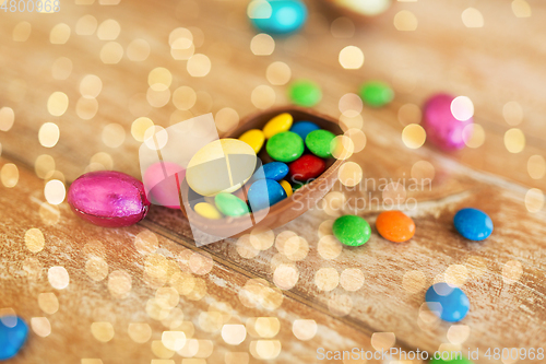 Image of chocolate egg and candy drops on wooden table