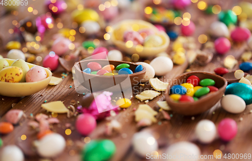 Image of chocolate eggs and candy drops on wooden table