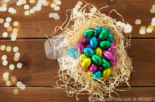 Image of chocolate eggs in foil wrappers in straw nest