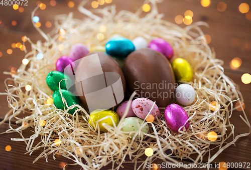 Image of chocolate eggs in foil wrappers in straw nest