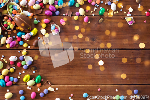 Image of chocolate eggs and candy drops on wooden table