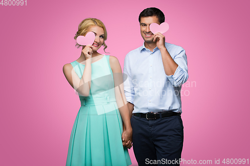 Image of Beautiful couple holding pink hearts