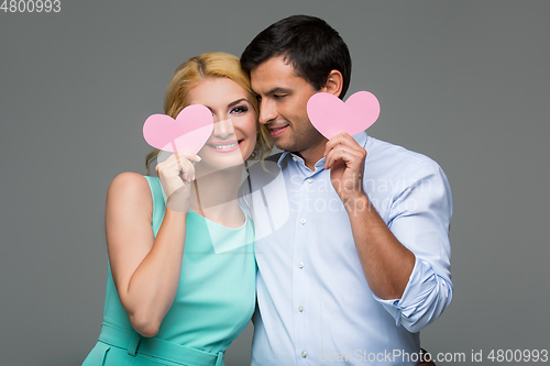 Image of Beautiful couple holding pink hearts