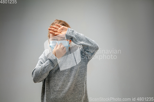 Image of Caucasian girl wearing the respiratory protection mask against air pollution and dusk on grey studio background