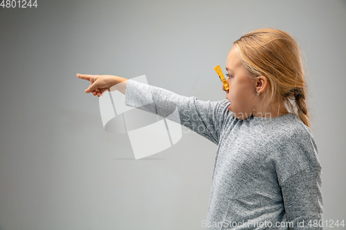 Image of Caucasian girl wearing the respiratory protection pin clasp against air pollution and dusk on grey studio background