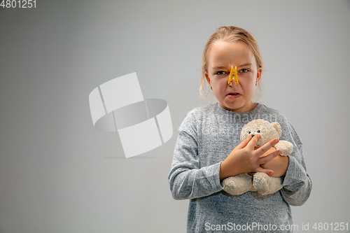 Image of Caucasian girl wearing the respiratory protection pin clasp against air pollution and dusk on grey studio background