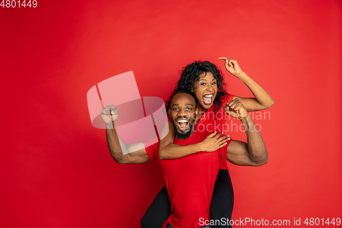 Image of Young emotional african-american man and woman on red background