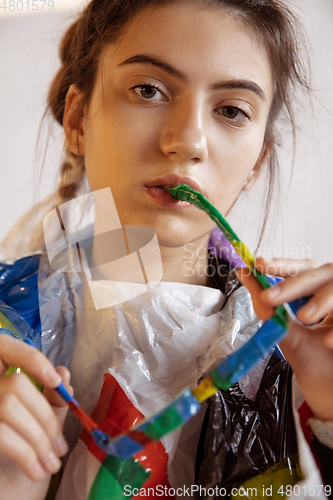 Image of Woman addicted of sales and clothes, wearing plastic, recycling concept