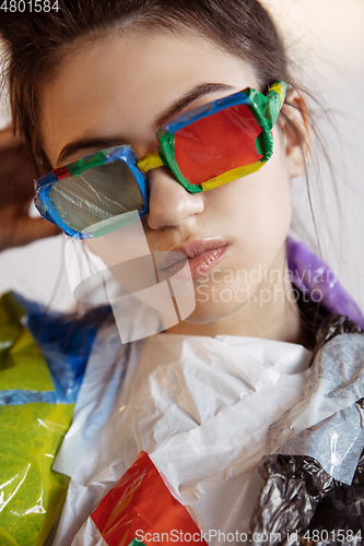 Image of Woman addicted of sales and clothes, wearing plastic, recycling concept