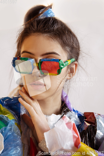 Image of Woman addicted of sales and clothes, wearing plastic, recycling concept