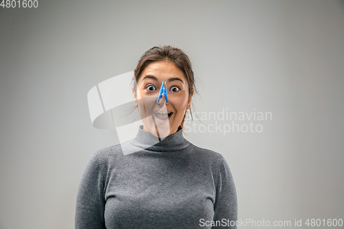 Image of Caucasian woman wearing the respiratory protection pin clasp against air pollution and dusk on grey studio background
