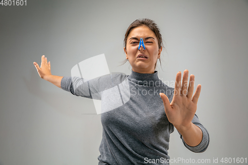 Image of Caucasian woman wearing the respiratory protection pin clasp against air pollution and dusk on grey studio background