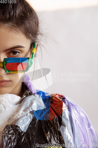 Image of Woman addicted of sales and clothes, wearing plastic, recycling concept