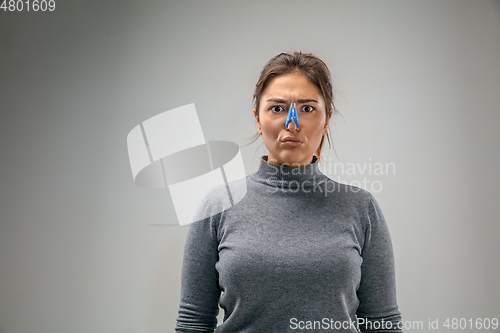 Image of Caucasian woman wearing the respiratory protection pin clasp against air pollution and dusk on grey studio background