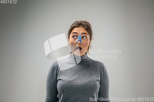 Image of Caucasian woman wearing the respiratory protection pin clasp against air pollution and dusk on grey studio background