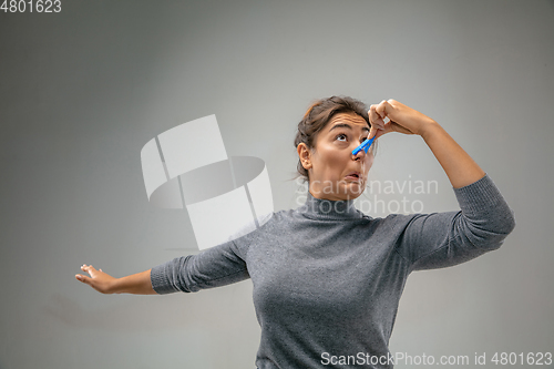 Image of Caucasian woman wearing the respiratory protection pin clasp against air pollution and dusk on grey studio background