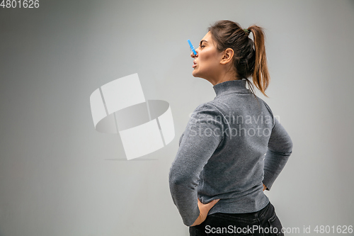 Image of Caucasian woman wearing the respiratory protection pin clasp against air pollution and dusk on grey studio background