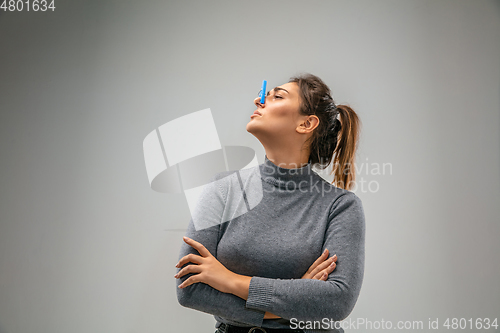 Image of Caucasian woman wearing the respiratory protection pin clasp against air pollution and dusk on grey studio background