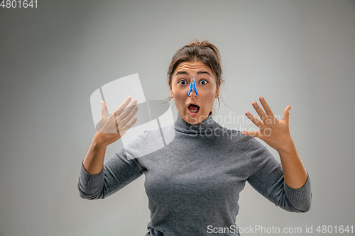 Image of Caucasian woman wearing the respiratory protection pin clasp against air pollution and dusk on grey studio background