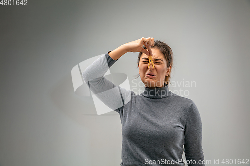 Image of Caucasian woman wearing the respiratory protection pin clasp against air pollution and dusk on grey studio background