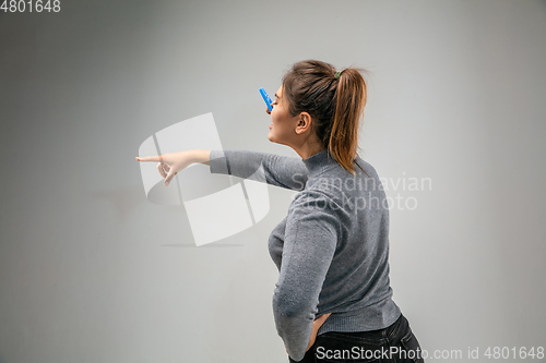 Image of Caucasian woman wearing the respiratory protection pin clasp against air pollution and dusk on grey studio background