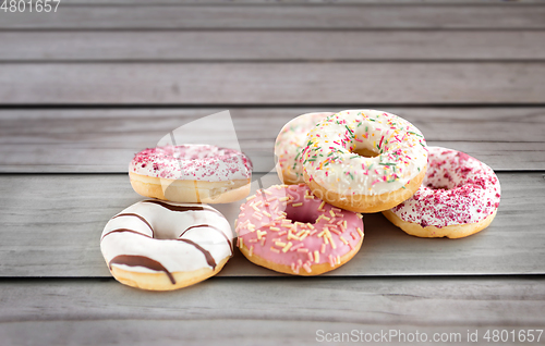 Image of close up of glazed donuts on wooden boards