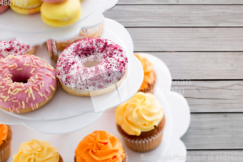 Image of close up of glazed donuts and cupcakes on stand