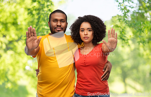 Image of african american couple showing stop gesture