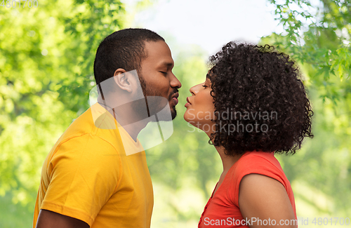 Image of happy african american couple reaching for kiss