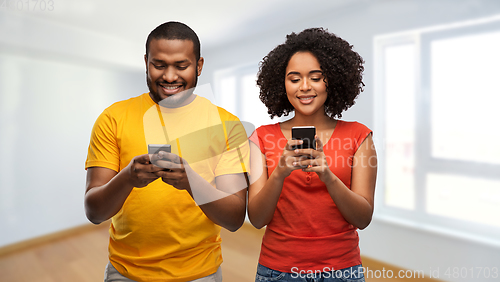 Image of happy african american couple with smartphones