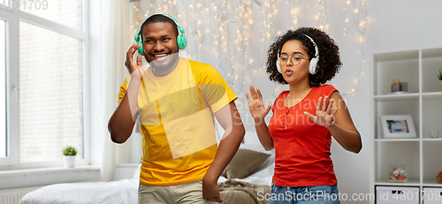 Image of african american couple with headphones dancing