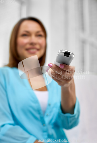 Image of close up of woman with tv remote control at home