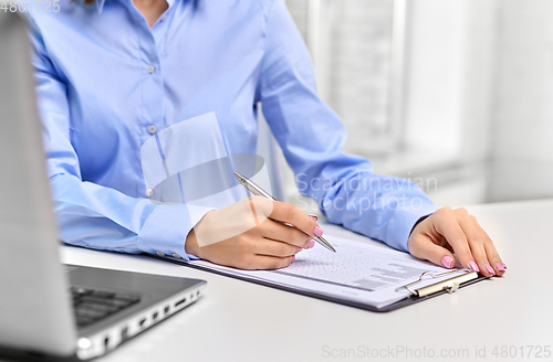 Image of businesswoman with papers working at office