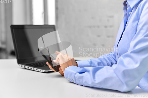 Image of businesswoman with smartphone at office