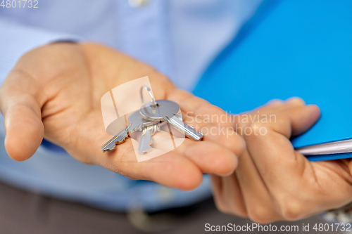 Image of close up of male hands holding keys and folder