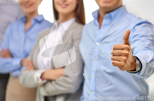 Image of close up of happy businessman showing thumbs up