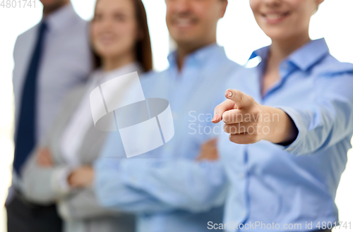 Image of close up of smiling businesswoman pointing finger