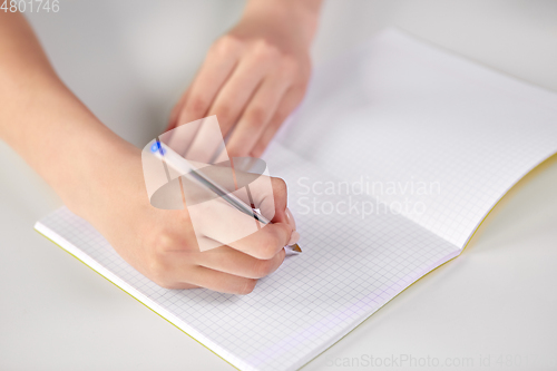 Image of hands of student girl with pen writing to notebook