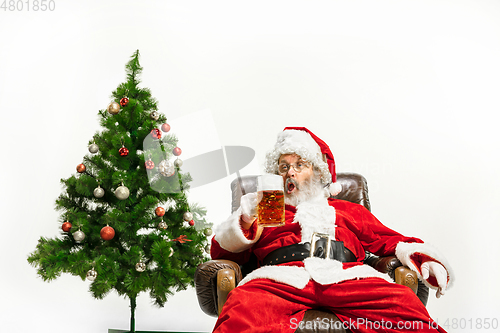 Image of Santa Claus drinking beer near Christmas tree, congratulating of New Year 2020