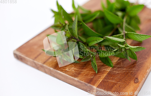 Image of bunch of fresh peppermint on wooden cutting board