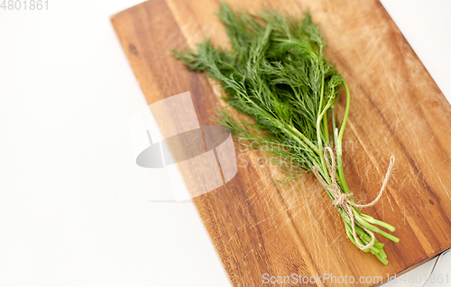 Image of bunch of dill on wooden cutting board