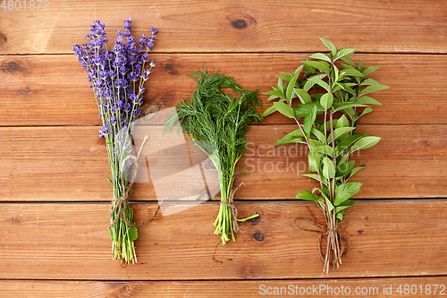 Image of lavender, dill and peppermint on wooden background