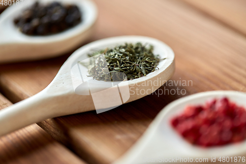 Image of spoons with different spices on wooden table