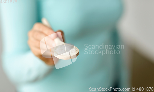 Image of close up of woman with sea salt on wooden spoon